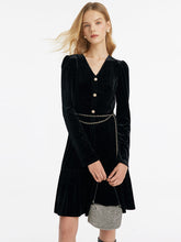 A lady wears a v-neck velvet dress to the casino.